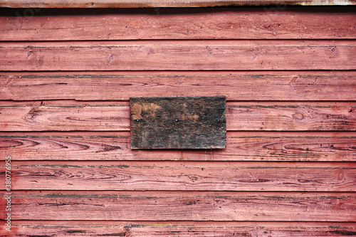 Rustic red painted wooden wall with unpainted wood sign board photo