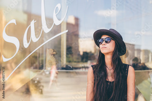Girl in hat in front of show window