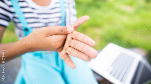 Close up of ameican african kid hands applying alcohol gel at school.Coronavirus prevention medical hand sanitizer gel for hygiene. covid-19 virus protection.Hand washing before learning.new normal. photo