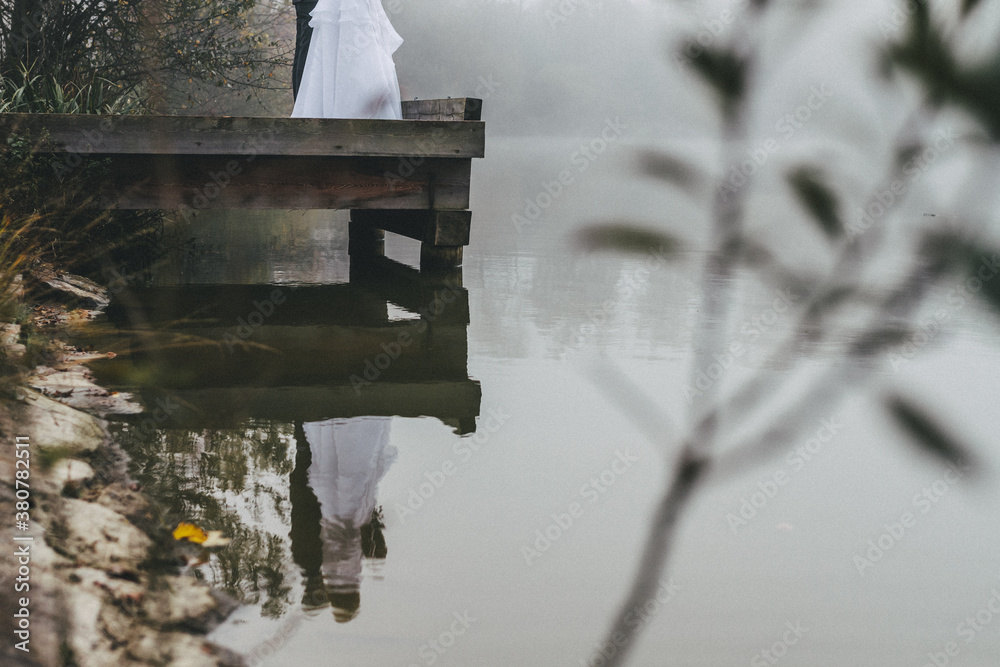 reflection of a bride and groom on jetty reflection of a bride and groom on jetty