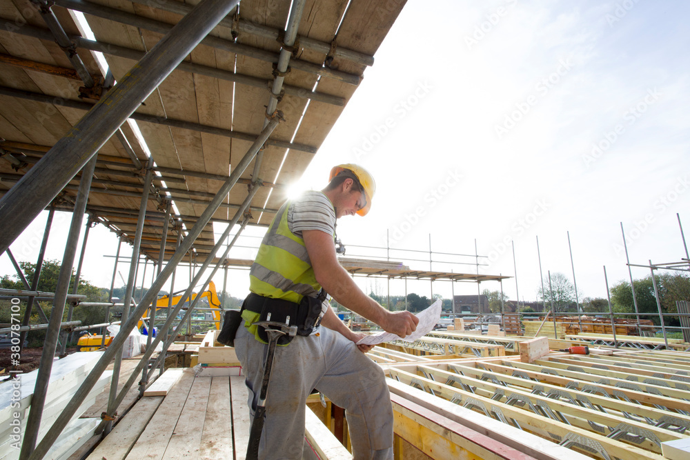 © Hugh Sitton/Stocksy - Construction site (carpenters working on house build).