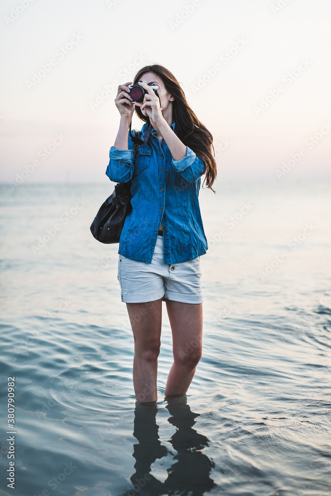 Female photographer walking on the beach Female photographer walking on the beach