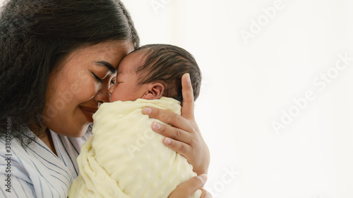 mixed race african american and asian mother holding newborn baby