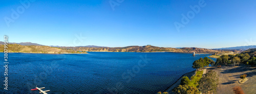 a majestic aerial shot of the still deep blue lake waters, gorgeous mountain ranges and blue sky at Castaic Lake in the Sierra Pelona Mountains of northwestern Los Angeles County, California photo