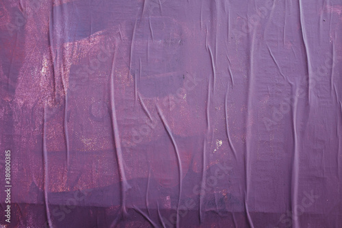 Purple paint covering graffiti tags on building wall