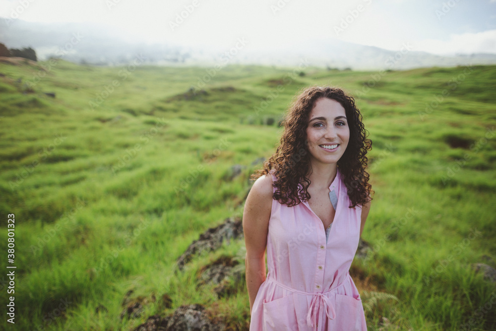 Beautiful woman with curly brown hair smiling outside in nature Beautiful woman with curly brown hair smiling outside in nature
