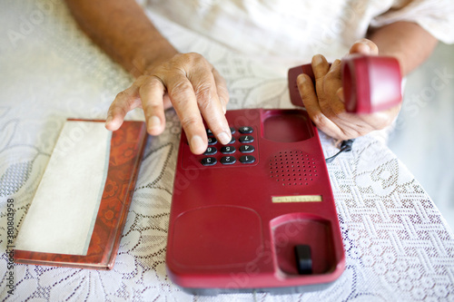 Active Senior dialing a vintage telephone photo