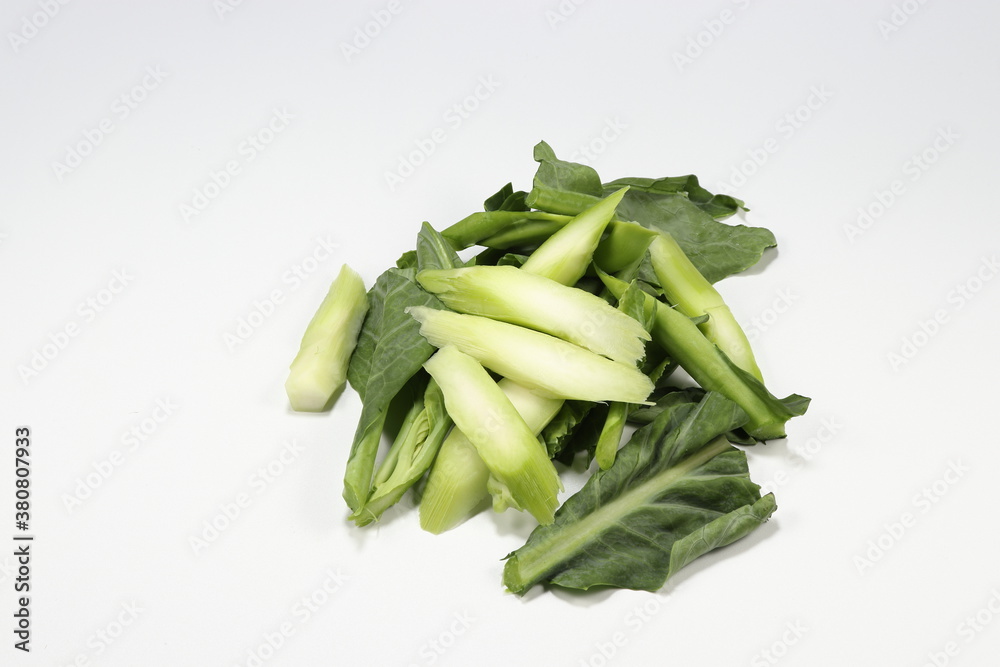 Pile of sliced or cutting Chinese kale isolated on the white background. Famous traditional ingredient of stirred vegetarian menu in Asia restaurant. Preparation food concept. Pile of sliced or cutting Chinese kale isolated on the white background. Famous traditional ingredient of stirred vegetarian menu in Asia restaurant. Preparation food concept.