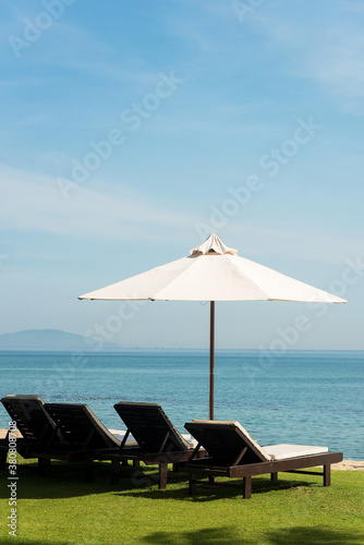 Beach with chaise longues and umbrella against sea photo