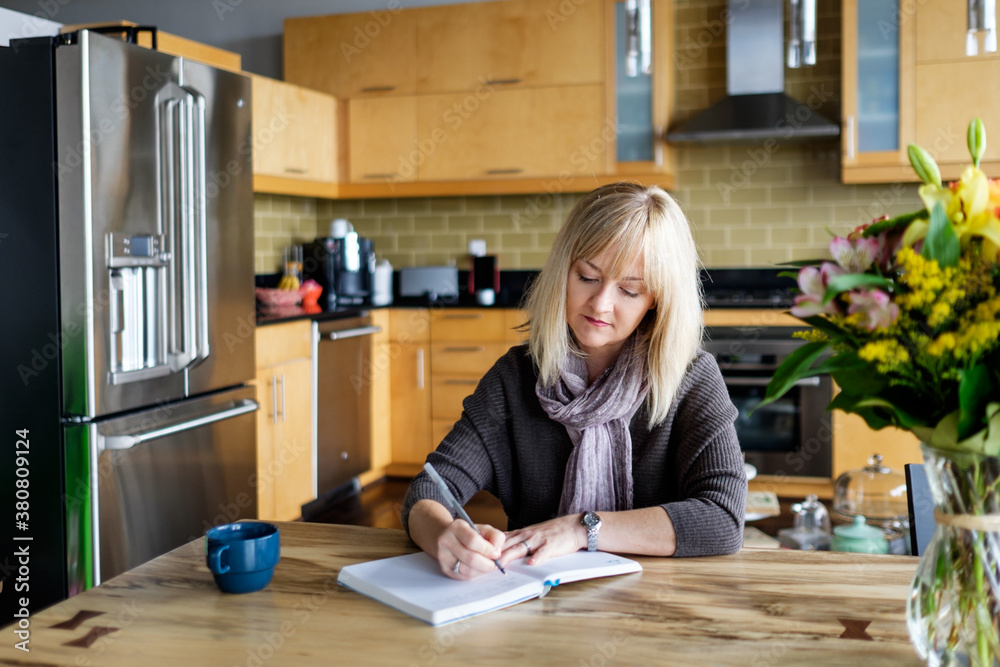 Woman writing on a notebook at home Woman writing on a notebook at home