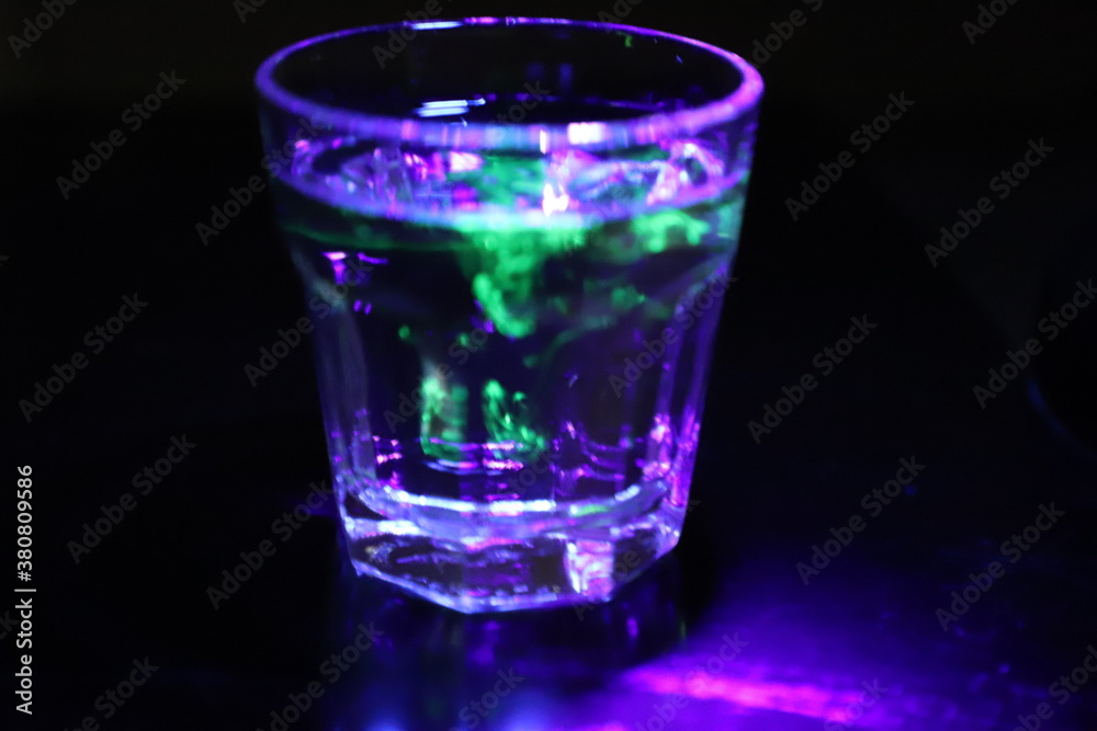 A Glass with a Glowing Green and Yellow Liquid Swirling Around Inside A Glass with a Glowing Green and Yellow Liquid Swirling Around Inside