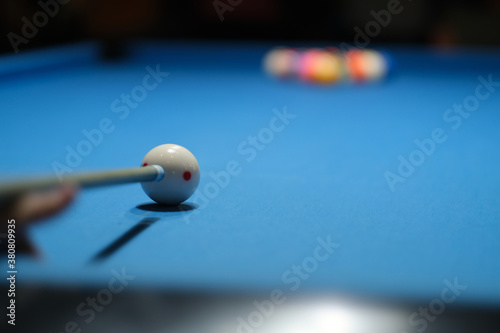 first person view of holding pool cue aiming at cue ball to break. beginning of snooker match. soft focus