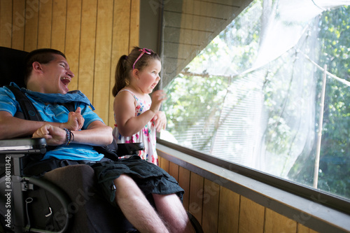 Little Girl and Young Man in a Wheelchair looking out a window at the Melbourne Zoo photo