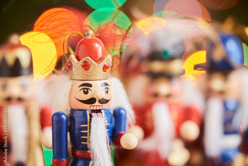 Traditional Christmas nutcrackers with colored lights in the background.