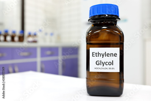 Selective focus of ethylene glycol liquid chemical compound in dark glass bottle inside a chemistry laboratory with copy space. photo