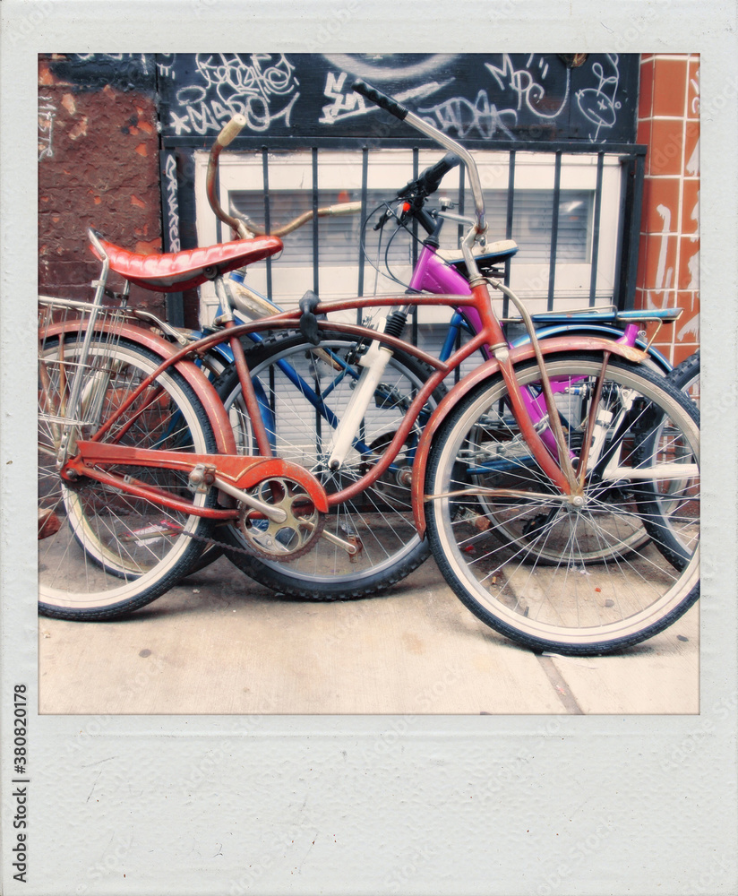 Old polaroid photograph of bicycles locked together on a city sidewalk Old polaroid photograph of bicycles locked together on a city sidewalk