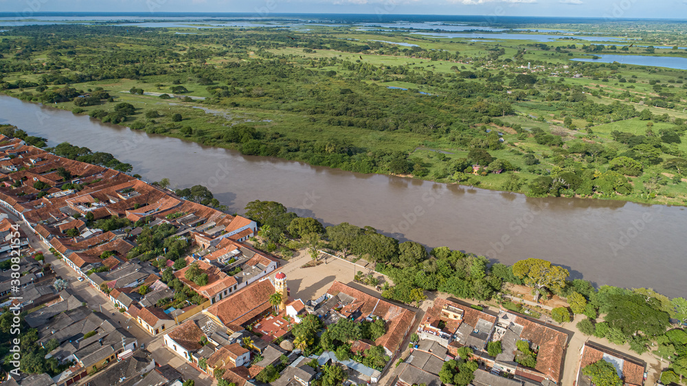 Aerial view of the historic town Santa Cruz de Mompox in sunlight with river and green sourrounding, World Heritage