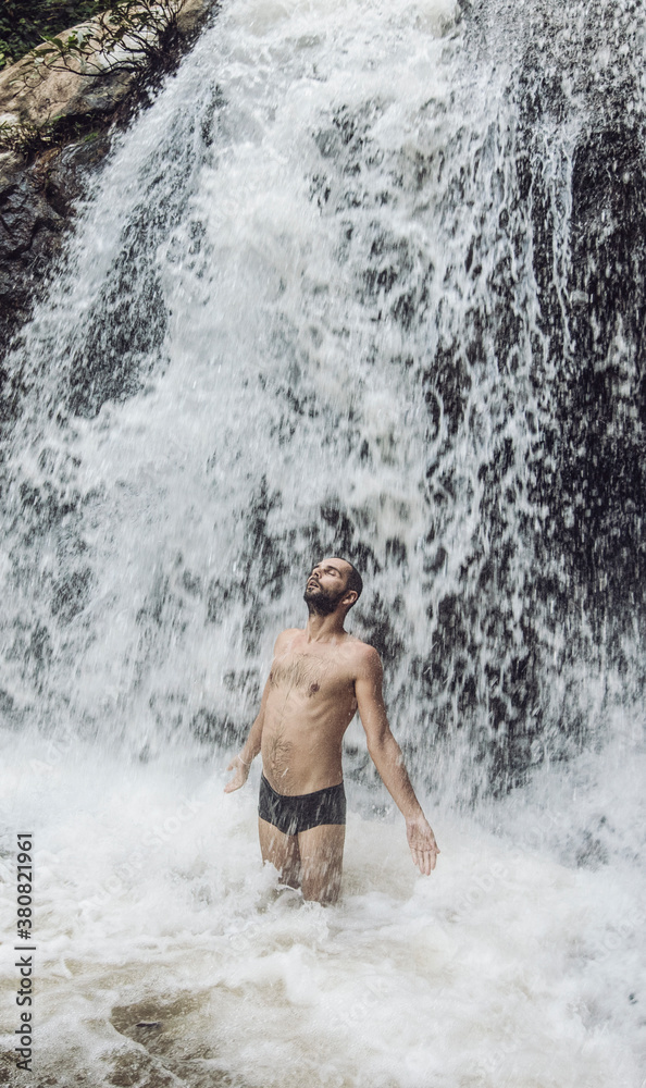 Caucasian Man Relaxing under a Waterfall Caucasian Man Relaxing under a Waterfall