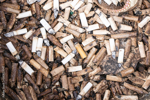 Discarded cigarette buts in a large ash tray photo