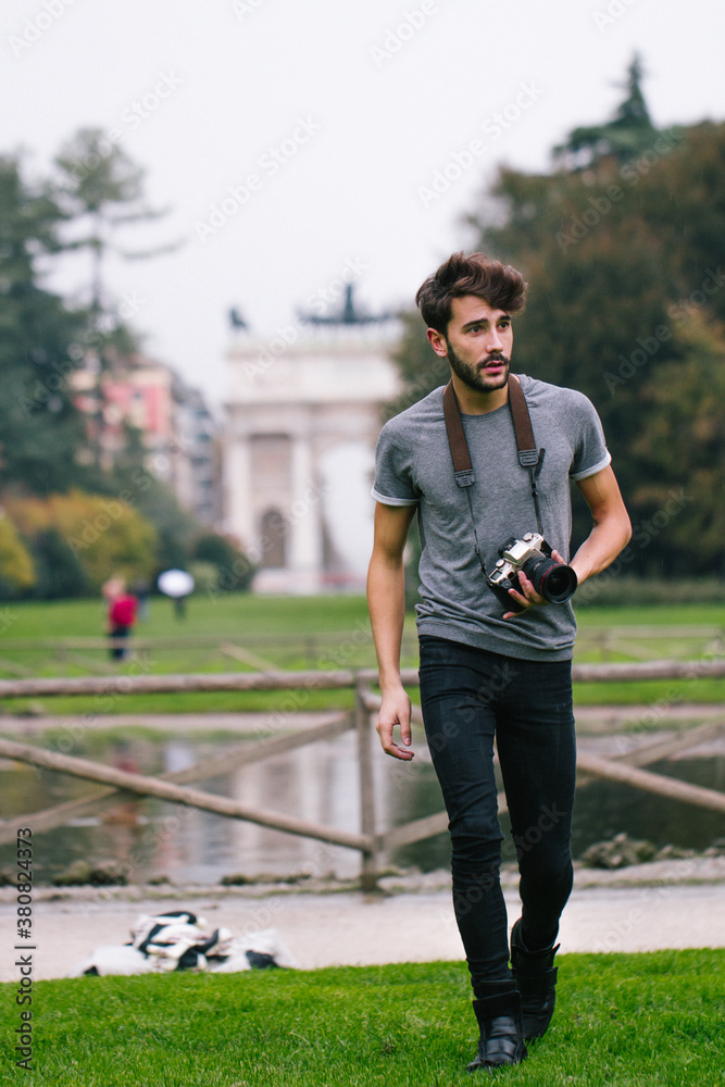 Young man takes pictures at the park with a reflex