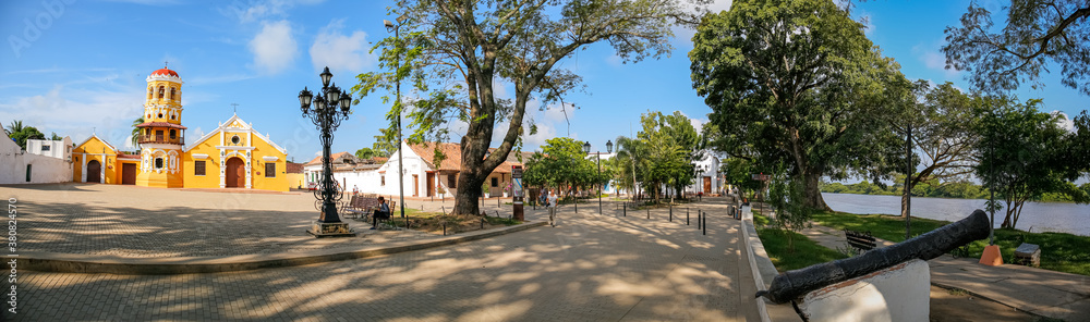 Panorama of  Church of Santa Barbara and river promenade with a historic cannon in Santa Cruz de Mompox, Colombia
