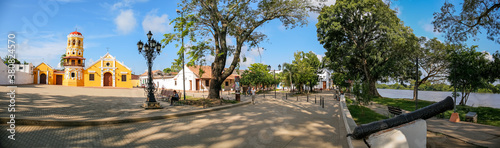 Panorama of Church of Santa Barbara and river promenade with a historic cannon in Santa Cruz de Mompox, Colombia 