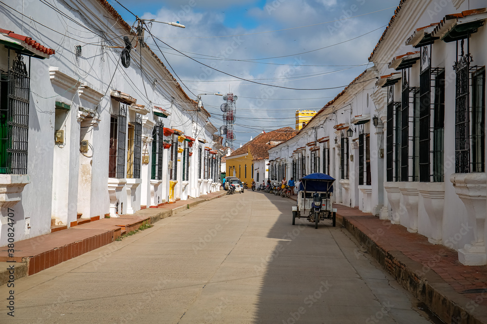 Typical street with white historic buildings in sun and shadow of Santa Cruz de Mompox, Colombia, World Heritage