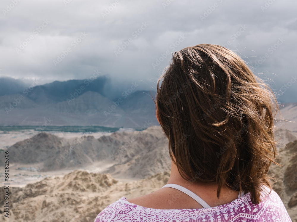 Girl from behind looking at Ladakh mountains Girl from behind looking at Ladakh mountains