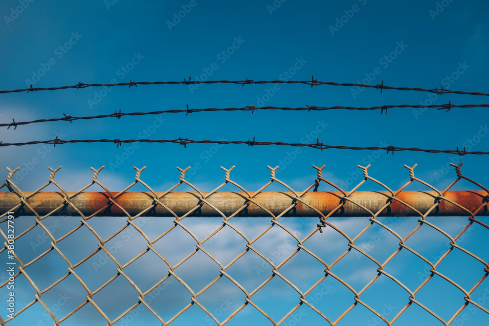 Detail of barbed wire and chain-link fence Detail of barbed wire and chain-link fence