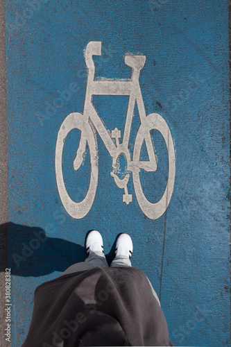 Feet standing on bike lane photo