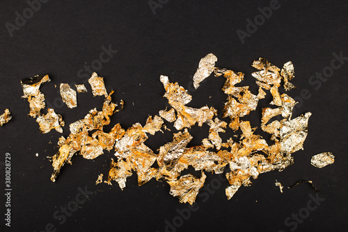 Gold luxury wealth holiday background. Gold foil flakes, patal, on the background. View from above. Finished work for your project. Luxury,