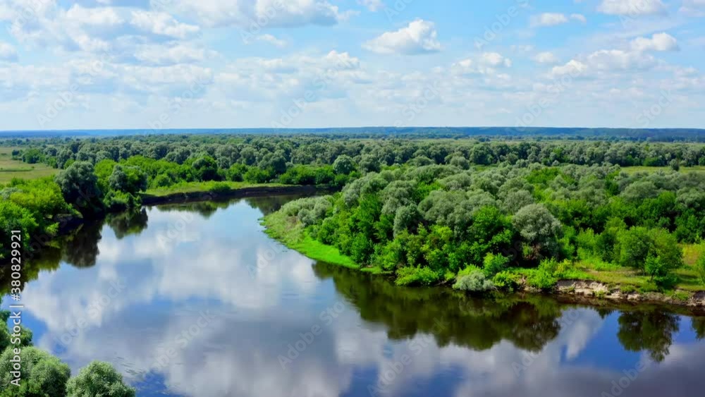 Aerial cinematic view: Drone flies above a beautiful summer landscape with a river while afternoon. Aircraft flies over amazing landscape in spring, half cloudy day. Bird view to a river. Aerial cinematic view: Drone flies above a beautiful summer landscape with a river while afternoon. Aircraft flies over amazing landscape in spring, half cloudy day. Bird view to a river.