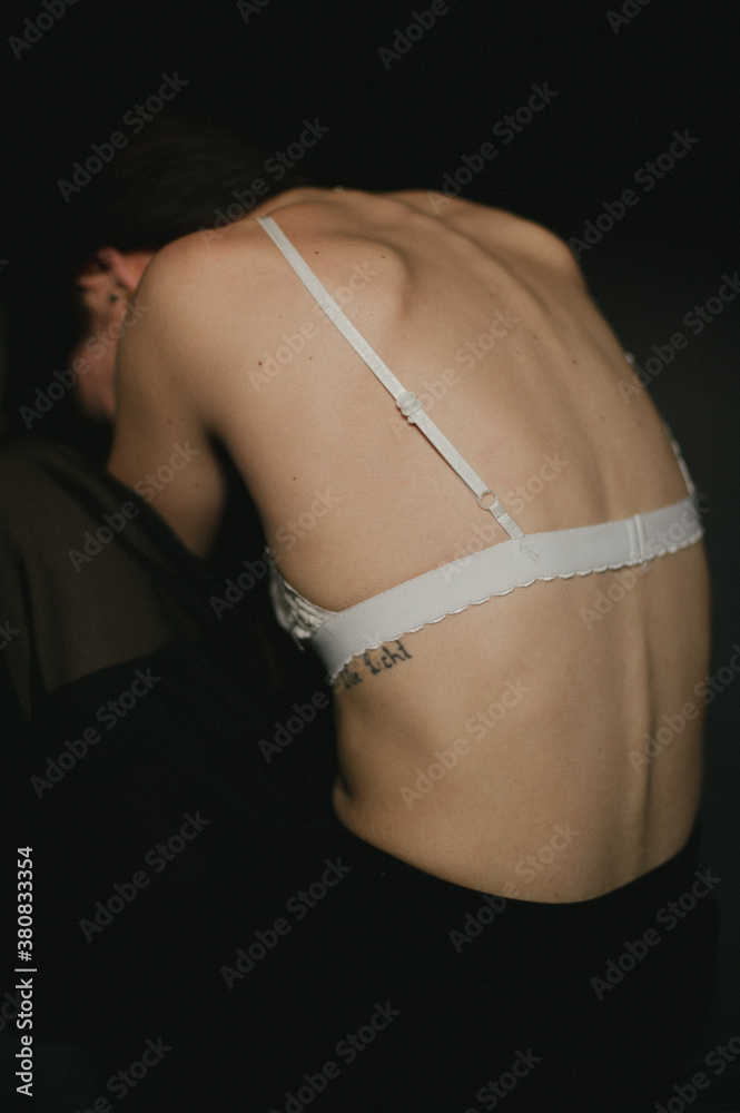 Skinny girl wearing white bra with boney spine showing Stock Photo