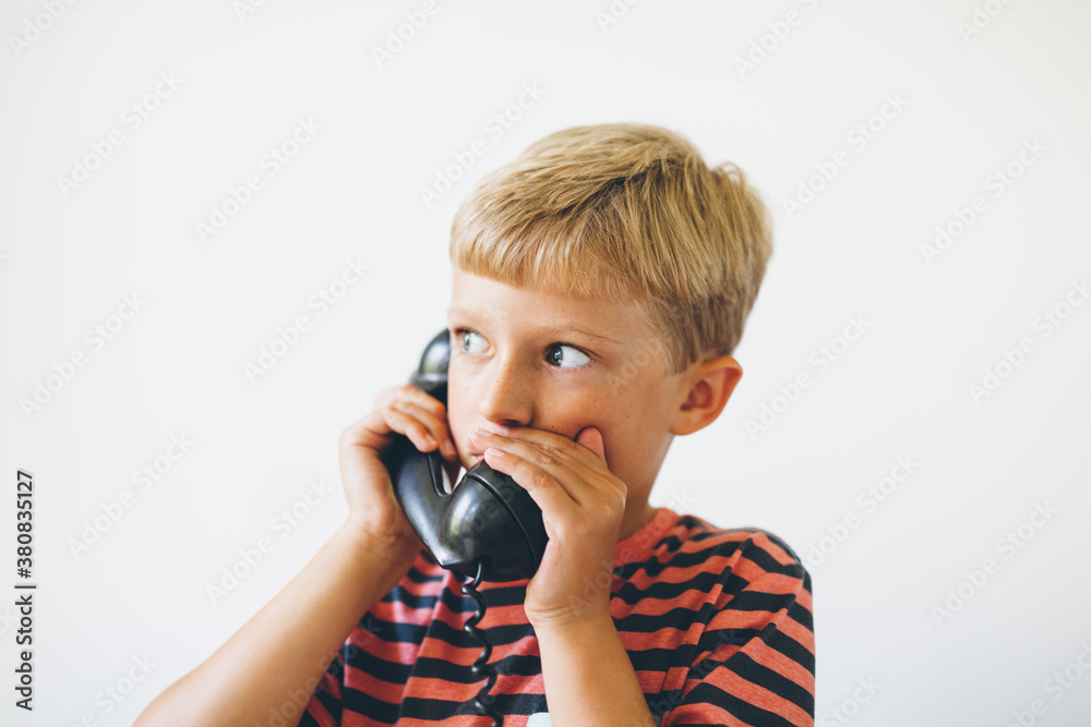 boy talking on a retro telephone boy talking on a retro telephone
