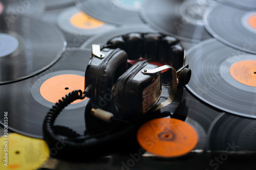 Old big headphones on vinyl records photo