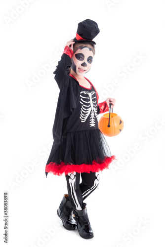 Full length of asian girl in halloween skeleton costume holding pumpkin bucket standing isolated over white background .