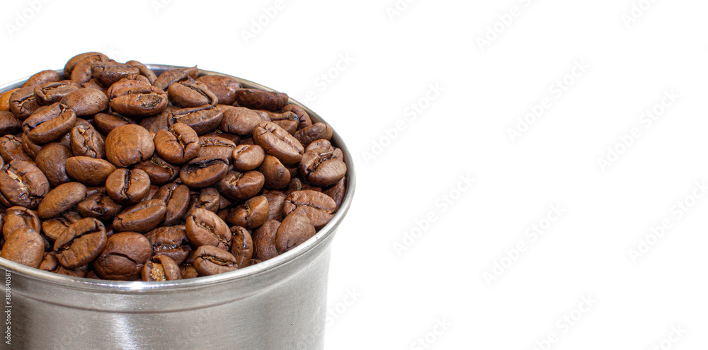 A lot of coffee beans in a metal coffee grinder on a white background A lot of coffee beans in a metal coffee grinder on a white background