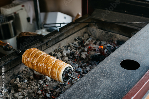 Chimney cake baking over charcoals photo