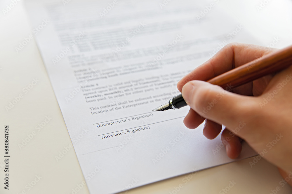 Close up of hand signing document. Close up of hand signing document.
