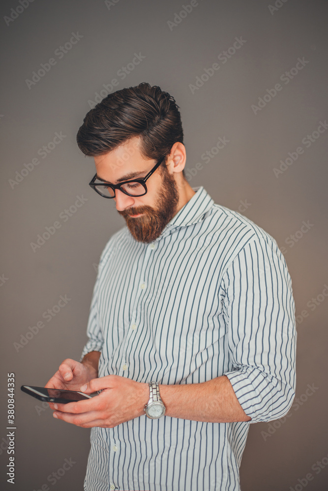 Young businessman using phone in the office. Young businessman using phone in the office.