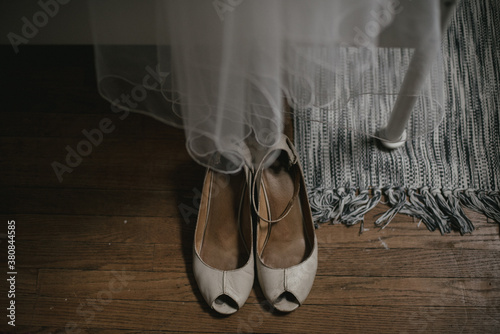 Vintage bridal wedding shoes on wood floor with veil