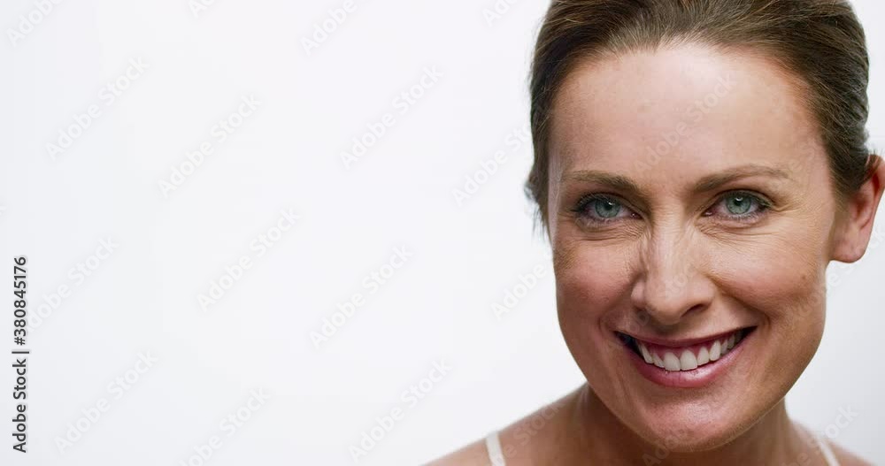 Portrait of a woman looking down off camera, then looking into camera smiling. Portrait of a woman looking down off camera, then looking into camera smiling.