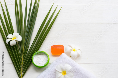 natural herbal coconut scrub health care for surface skin face with herbal soap for cleaner ,coconut leaf ,flowers frangipani and terry cloth arrangement flat lay style on background white 