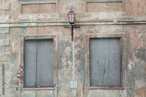 Decaying boarded up house covered with a protective net, just a lantern sticking out photo