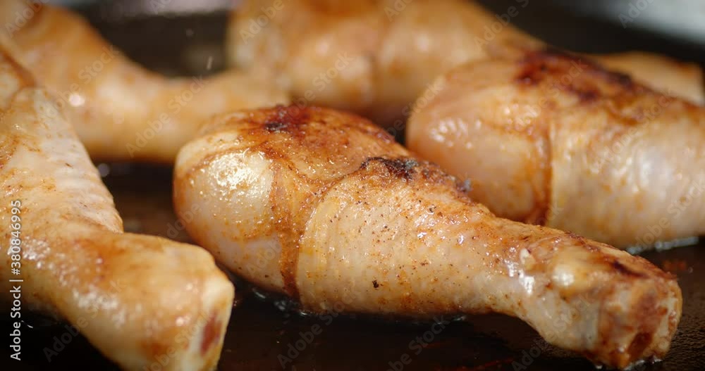 The pan with fried chicken drumsticks slowly rotates. The pan with fried chicken drumsticks slowly rotates.