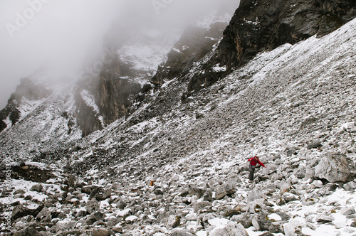 Female trekker climbing loose scree while climbing an alternate route to Kongma La Pass, Everest Region, Sagarmatha National Park, Nepal. photo