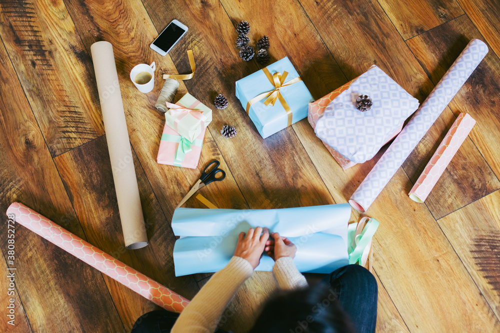 Overhead of a woman wrapping Christmas gifts at home. Overhead of a woman wrapping Christmas gifts at home.