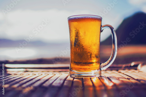 Ice cold jug of beer on a hot summer day on table