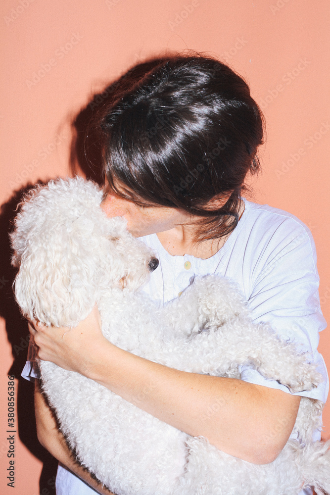 Brunette woman hugging and kissing her dog Brunette woman hugging and kissing her dog