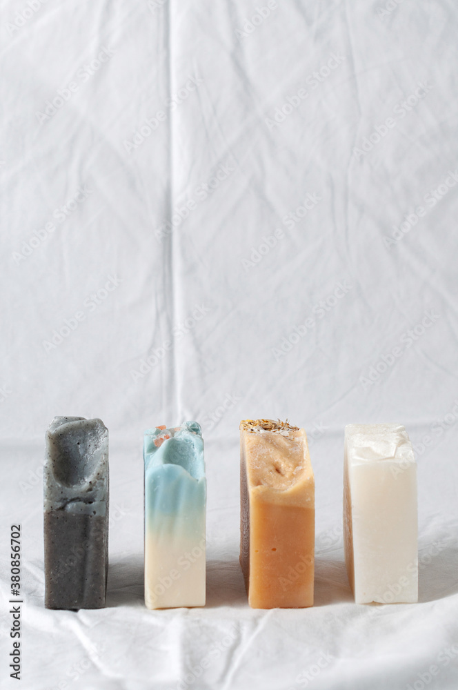 Four types of natural handmade soap bar on white cloth background